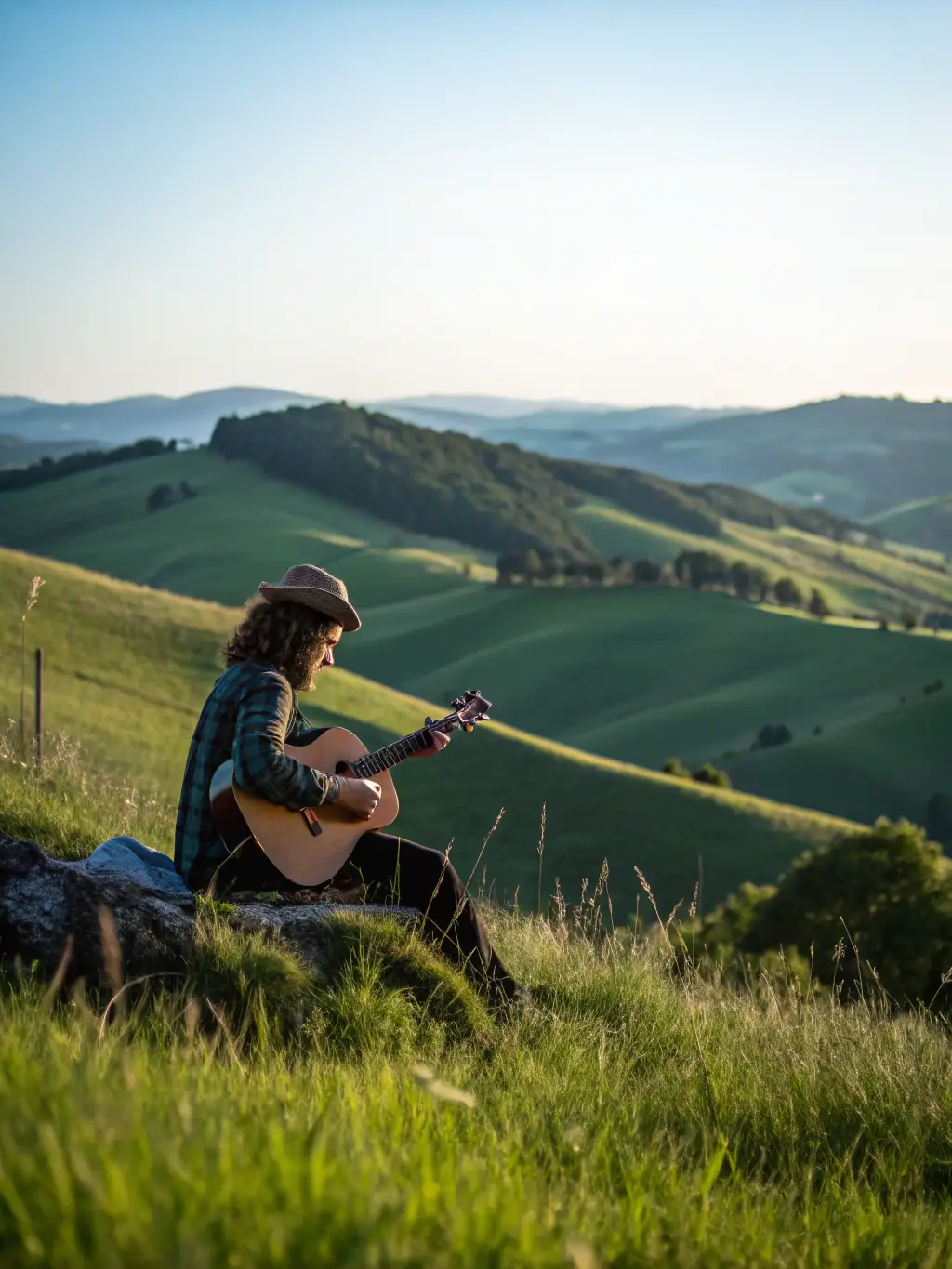A poster featuring a silhouette of a musician against a sunset backdrop, advertising an outdoor acoustic concert.